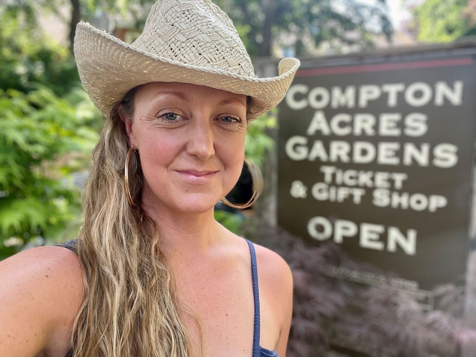 Grace standing in front of Compton Acres entrance sign 